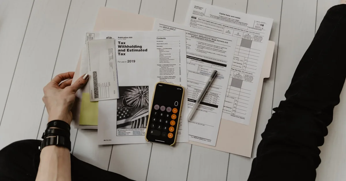 Dirigeant d'une TPE étudiant la grille tarifaire de sa Caisse régionale pour son compte professionnel sur un ordinateur portable